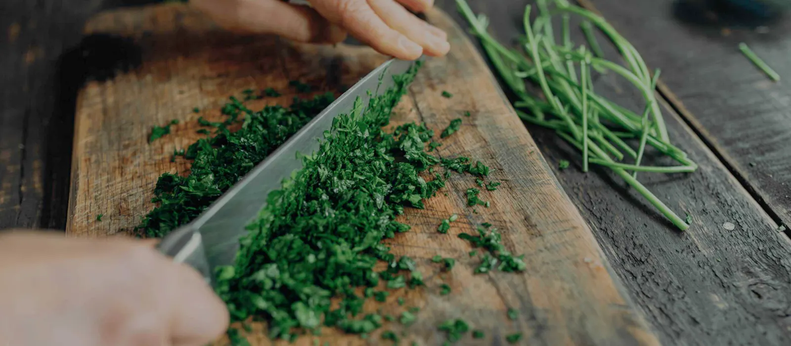 Herbs being chopped on a wooden board